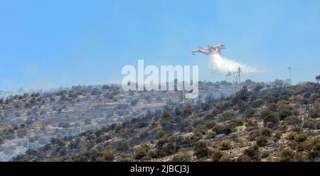 Athens, Greece, June 4, 2022: A firefighting Canadair CL-215 aircraft operates in Hymettus mount wildfire near Glyfada suburb of Athens. Stock Photo