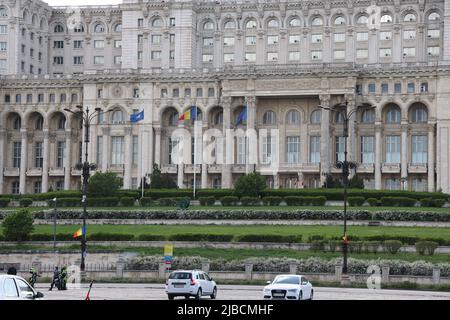 NATO, Romanian & EU flags in front of the House of the people in Bucharest, Romania; the 2nd largest building in the world. Seat of the parliament Stock Photo