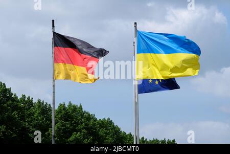 The flags of Ukraine, Germany, and the EU waving in the wind Stock Photo