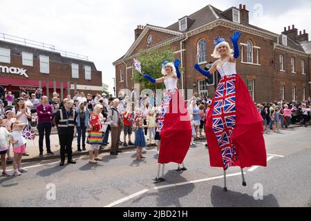 Queens Platinum Jubilee parade, stilt walker; two women walking on stilts as part of the celebrations, Newmarket Suffolk UK, June 2022 Stock Photo