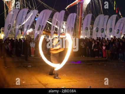 Young man dancing dance with fire fan in her hand.fire show at Varna Port,Bulgaria Stock Photo