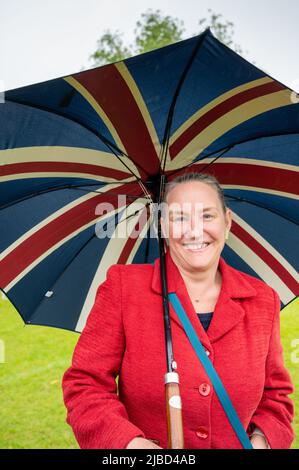 Willingham Cambridgeshire, UK. 5th June, 2022. People celebrate the Queen's Platinum Jubilee weekend in the rain at a picnic on the recreation ground. Lot's of people were determined to celebrate the occasion despite the drizzling rain, bringing their own picnics and enjoying a blues band, food stalls, bar and games. Credit: Julian Eales/Alamy Live News Stock Photo