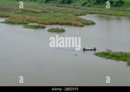 Two people rowing boat in river in India Stock Photo