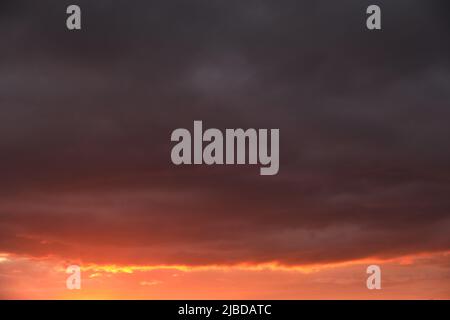 Thunderclouds with breaking rays sun at sunset Stock Photo