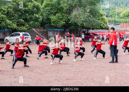 Disciples at the Shaoling Temple in Henan practice their kungfu exercises in one of the training fields at the temple. Stock Photo