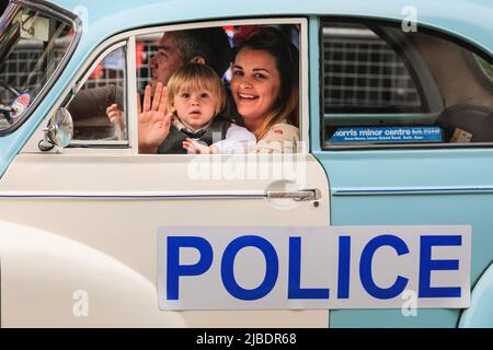 London, UK. 05th June, 2022. The passengers of a vintage police car happily wave at the crowds. The Platinum Jubilee Pageant features 10,000 participants in four acts, 'For Queen and Country', a military parade, 'The Time of Our Lives', showing the 7 decades of the Queen's reign, including 150 'national treasure' celebrities and celebrating culture, music and fashion, 'Let's Celebrate', and 'Happy and Glorious', the final forming in front of Buckingham Palace. Credit: Imageplotter/Alamy Live News Stock Photo