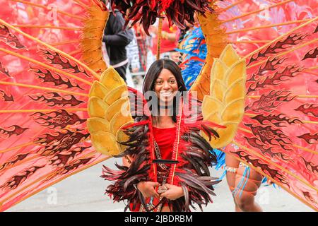 London, UK. 05th June, 2022. A participant beams at the crowds in her colourful costume. The Platinum Jubilee Pageant features 10,000 participants in four acts, 'For Queen and Country', a military parade, 'The Time of Our Lives', showing the 7 decades of the Queen's reign, including 150 'national treasure' celebrities and celebrating culture, music and fashion, 'Let's Celebrate', and 'Happy and Glorious', the final forming in front of Buckingham Palace. Credit: Imageplotter/Alamy Live News Stock Photo