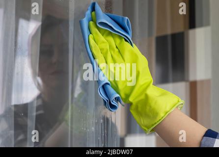 Wiping the window from dirt. Blue rag. Hand wipes the window. Stock Photo