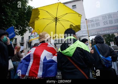 London, UK. 04th June, 2022. A demonstrator holds a yellow umbrella while wearing a British Union Jack flag during the Tiananmen Remembrance Vigil Rally to mark the 33rd anniversary of the 1989 pro-democracy movement and the Tiananmen Square massacre, outside the Chinese Embassy in London. Credit: SOPA Images Limited/Alamy Live News Stock Photo