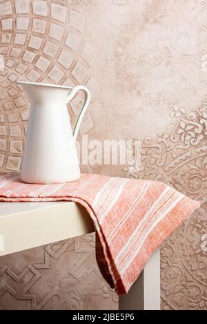 a white vintage jug stands on a towel Stock Photo