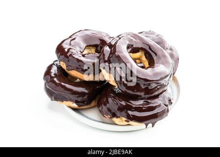 Ring-shaped  dark chocolate covered eclairs isolated on white Stock Photo