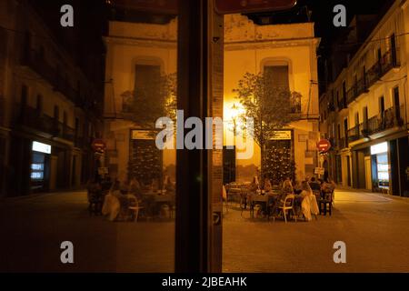 Arenys de Mar, Barcelona, Spain. 5th June, 2022. An alley with restaurants is reflected in a window in Arenys de Mar, Barcelona, Spain. (Credit Image: © Matias Basualdo/ZUMA Press Wire) Stock Photo