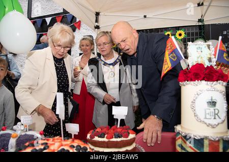 Cookham, Berkshire, UK. 5th June, 2022. Residents and their families and friends were having plenty of fun at the Cookham Jubilee Street Party today in Berkshire. They were joined by Actress Wendy Craig (left), Actor and Journalist Ross Kemp plus Mayor of the Royal Borough of Windsor and Maidenhead, Cllr Christine Bateson who did the judging of the best cake. The cakes were then sold off to raise money for the Thames Hospice charity. Credit: Maureen McLean/Alamy Live News Stock Photo