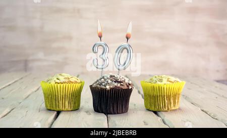 Happy birthday muffins with candles with the number. Card copy space with pies for congratulations. Stock Photo