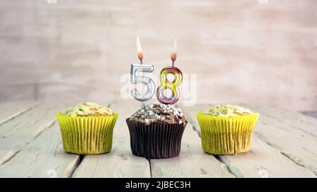 Happy birthday muffins with candles with the number. Card copy space with pies for congratulations. Stock Photo