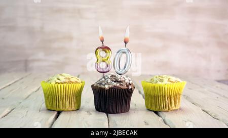 Happy birthday muffins with candles with the number. Card copy space with pies for congratulations. Stock Photo