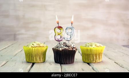 Happy birthday muffins with candles with the number. Card copy space with pies for congratulations. Stock Photo