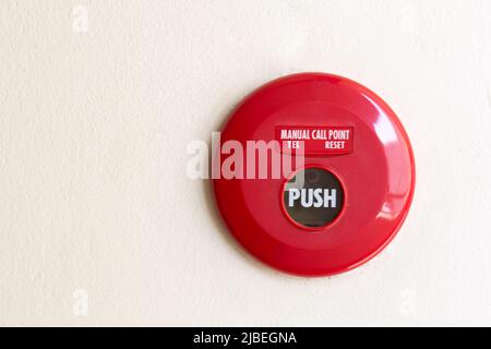 Red manual call point for fire alarm on the wall. Stock Photo