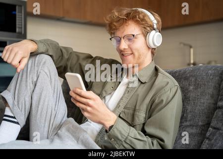 Young british ginger man in headset doing video call using mobile phone Stock Photo