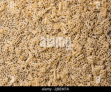 pasta letters or alphabet, full frame background, diet and food concept, taken from above, flat lay Stock Photo