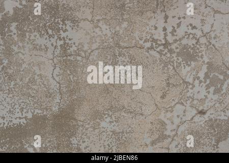 Old wall texture with two layers of peeling paint. Surface of an old cracked worn wall with layers of beige and white peeling paint. Stock Photo