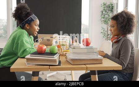African American students talking happily while sharing with thoughts in study room. Stock Photo