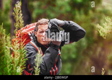 Wildlife photography professional photographer man taking pictures with slr camera equipment of birds and animals in nature. Hiker hiking on travel Stock Photo