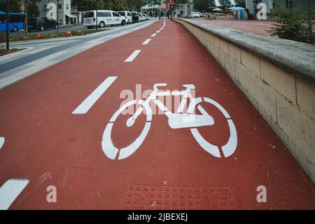 Bicycle lane sign on dedicated path with ruby red color background Stock Photo