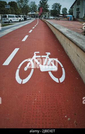 Bicycle lane sign on dedicated path with ruby red color background Stock Photo