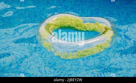 Floating rubber heart in water pool of crystal clean water surface. The concept of summer holidays, discounts, fun and summer.  Stock Photo