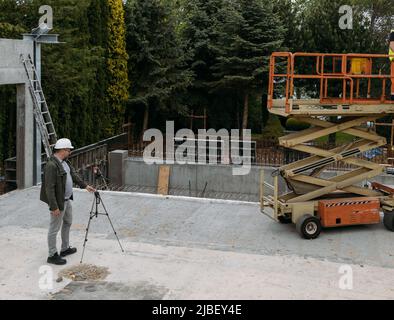 Geodetic works. Surveyor engineer using geodetic equipment at construction site. Professional equipment for building. work as a surveyor. Optical Stock Photo