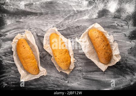 Assortment of delicious freshly baked bread on a black concrete background with flour top view copy space, banner Stock Photo