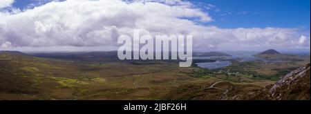 scenic panoramic vista over Connemara National Park with white clouds and blue sky in Spring Stock Photo