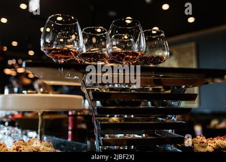 many glasses with cognac, whiskey stand on the bar. a lot of glasses with cognac. alcoholic beverages Stock Photo