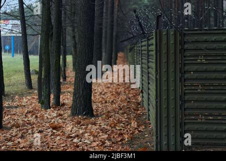 Tall fence with barbed wire angle shot outdoors autumn Stock Photo