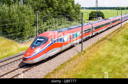 A Frecciarossa (ETR 1000) high speed train from italian rail company Trenitalia is driving from Lyon to Paris on the LGV Sud-Est in the countryside.