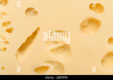 Swiss cheese slices with large holes texture background top view Stock Photo