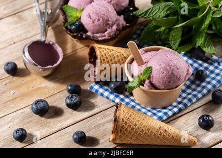 Blueberry ice cream scoops with waffle on wooden table Stock Photo