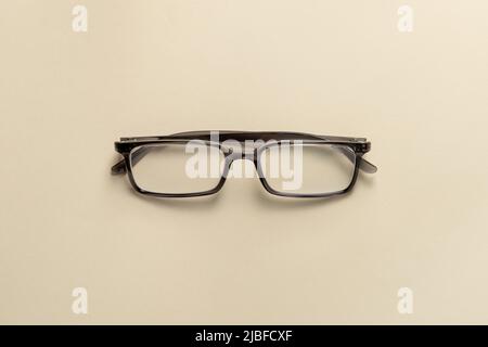 Top view of reading glasses on a cream table Stock Photo