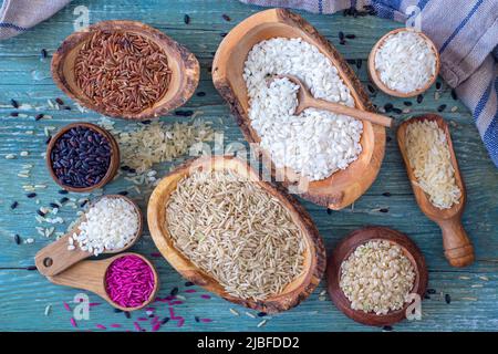 Different types of rice in wooden bowls Stock Photo