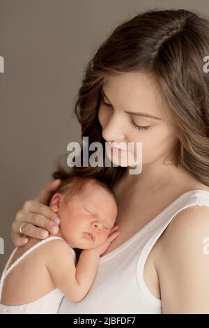 Newborn baby in mother's arms. Postcard Mother's Day and Easter. Children Protection Day. World Happiness Day. Smiling child and woman Stock Photo