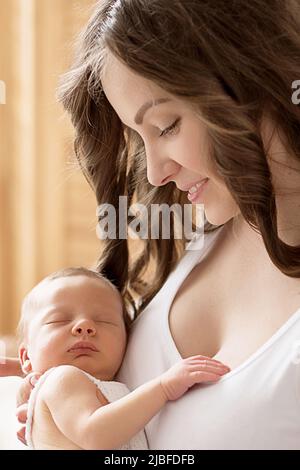 Newborn baby in mother's arms. Postcard Mother's Day and Easter. Children Protection Day. World Happiness Day. Smiling child and woman Stock Photo