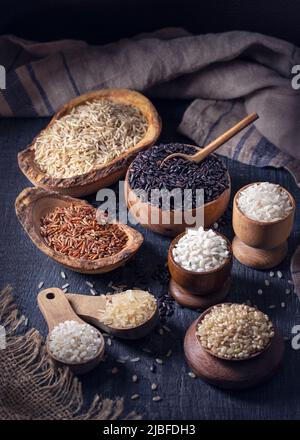 Different types of rice in wooden bowls Stock Photo