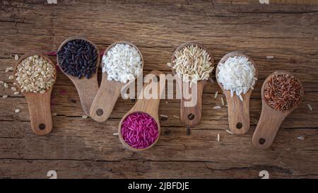 Different types of rice in wooden spoons Stock Photo