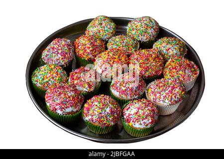 Homemade cupcakes decorated sugar sprinkles on metal tray. Group of homemade vanilla muffins white glazed multicolored decoration. Sweet cake baked at Stock Photo