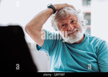 Crop female barkeeper putting ice cube with tongs into wineglass while preparing cocktail in bar with bottles on blurred background Stock Photo