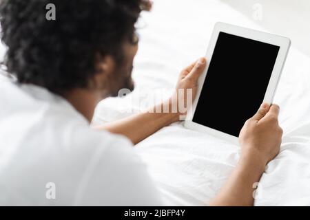 Dark-skinned man using digital tablet with blank screen Stock Photo