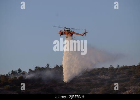 A firefighting Erickson Air Crane helicopter operates in the region of Voula  southern suburb, as wildfire blazes threatening surrounding homes. Athens, Greece, 4 June 2022. Credit: Dimitris Aspiotis / Alamy Stock Photo