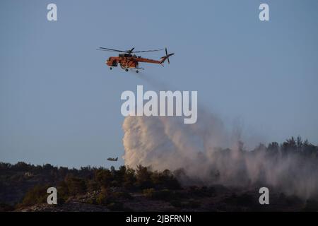 A firefighting Erickson Air Crane helicopter operates in the region of Voula  southern suburb, as wildfire blazes threatening surrounding homes. Athens, Greece, 4 June 2022. Credit: Dimitris Aspiotis / Alamy Stock Photo