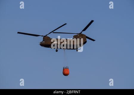 A firefighting Chinook helicopter operates in the region of Voula  southern suburb, as wildfire blazes threatening surrounding homes. Athens, Greece, 4 June 2022. Credit: Dimitris Aspiotis / Alamy Stock Photo